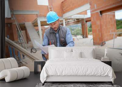 Construction manager checking blueprint on site Wall mural