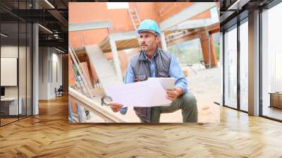 Construction manager checking blueprint on site Wall mural