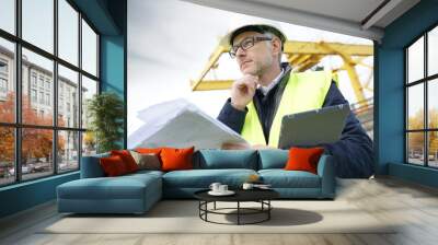 Construction manager on site reading blueprint Wall mural