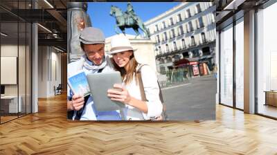 Couple checking on tourist information in Madrid Wall mural