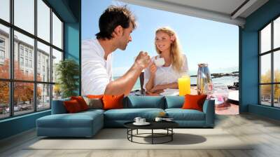 Couple having breakfast by blue lagoon Wall mural