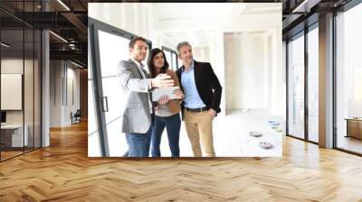 Couple with realtor visiting house under construction Wall mural