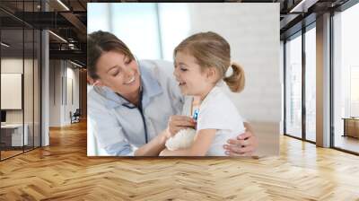 Doctor examining little girl with stethoscope Wall mural