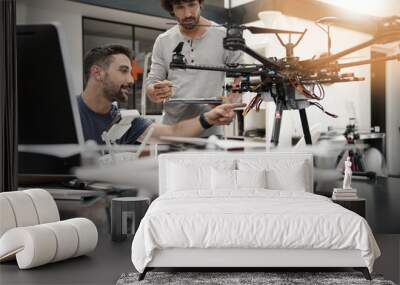 Engineer and technician working together on drone in office Wall mural