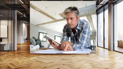 entrepreneur in house under construction checking plan Wall mural