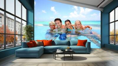 Family of four bathing in swimming pool Wall mural