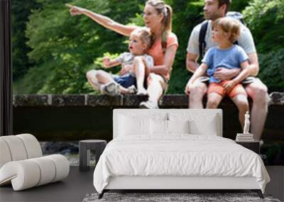 Family sitting on a bridge crossing mountain river Wall mural