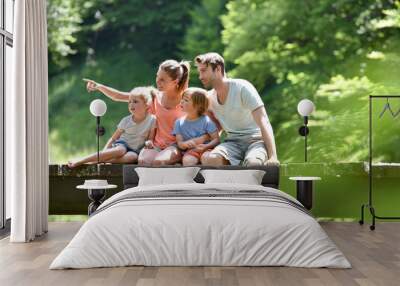 Family sitting on a bridge crossing mountain river Wall mural