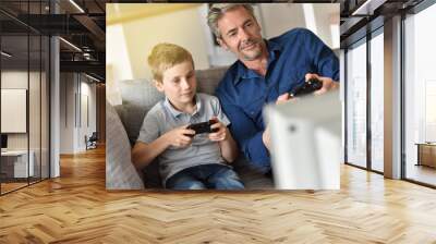 Father and son playing video game on tv Wall mural