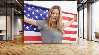 Gorgeous dynamic young woman smiling with big American flag on white background Wall mural