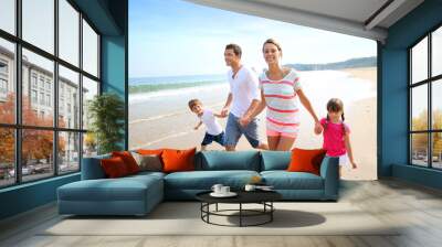 Happy family running on the beach Wall mural