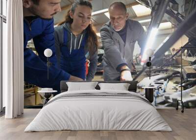 Instructor with trainees working on car engine Wall mural