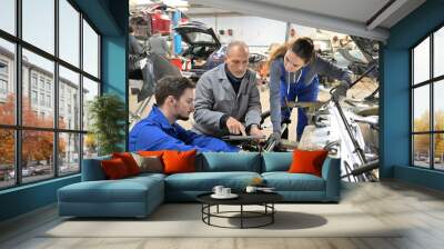 Instructor with trainees working on car engine Wall mural