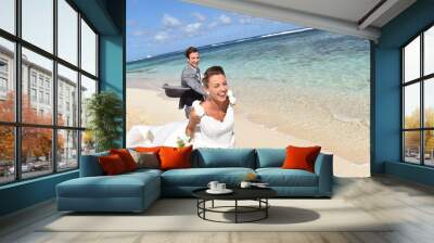 Just married couple running on a caribbean beach Wall mural