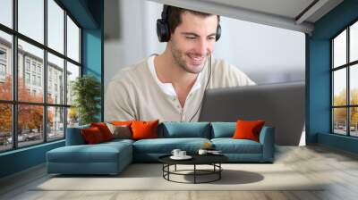 Man in front of laptop computer with headset Wall mural