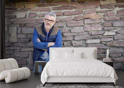 Man standing and leaning on stone wall Wall mural