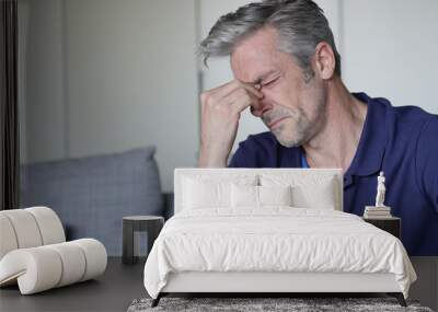 Mature man with bad headache at home Wall mural