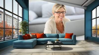 mature woman with eyeglasses websurfing on laptop Wall mural