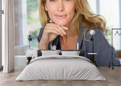 middle-aged blond woman working at home with laptop Wall mural