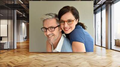 Middle-aged couple with eyeglasses on beige background Wall mural