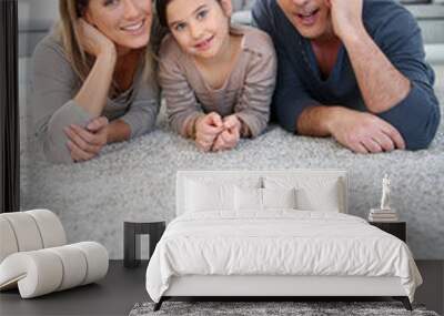 Middle-aged couple with little girl laying on carpet Wall mural