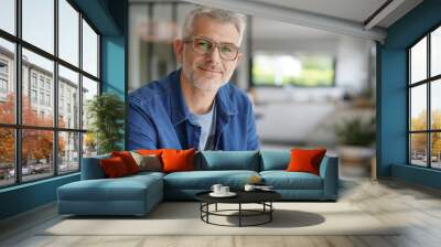 Middle-aged guy with eyeglasses and blue shirt Wall mural