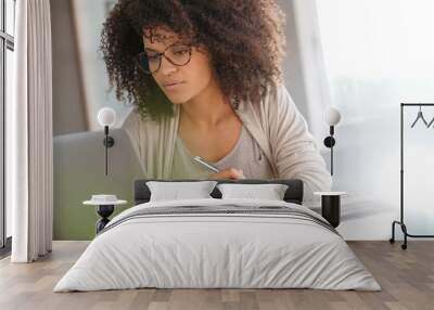 mixed race woman working from home on laptop computer Wall mural