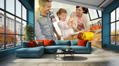 Parents with child cooking together at home Wall mural