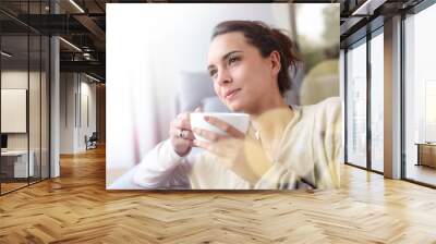 peaceful woman relaxing at home with cup of tea Wall mural