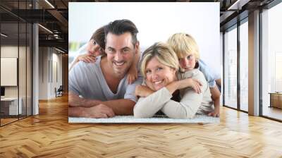 Portrait of happy family laying on carpet Wall mural