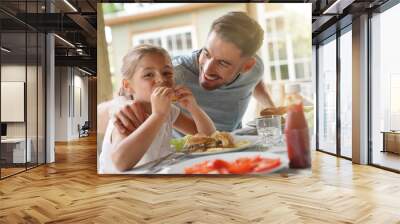 Portrait of man with little girl eating lunch together Wall mural