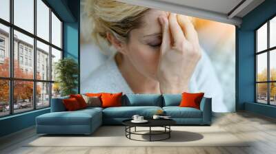 Portrait of middle-aged blond woman having a migraine Wall mural