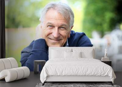 Portrait of senior man sitting in home garden Wall mural