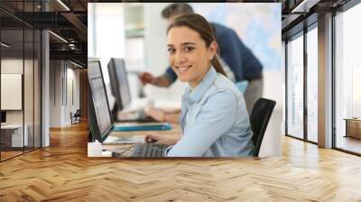 Portrait of smiling college girl working on desktop Wall mural