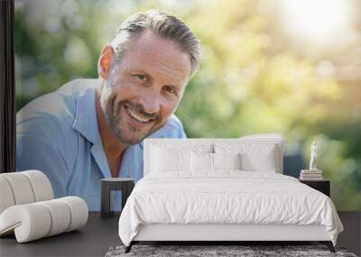 Portrait of smiling mature man relaxing outside Wall mural