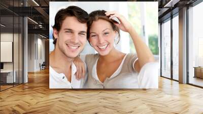 Portrait of smiling young couple at home Wall mural