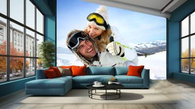 skier at the mountain giving piggyback ride to girlfriend Wall mural