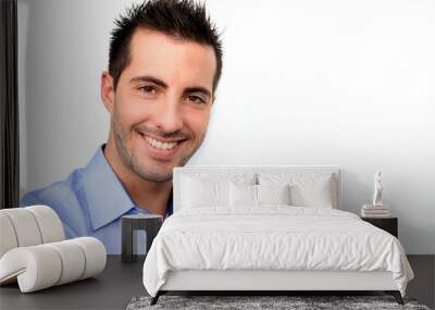 Smiling handsome guy leaning on white background Wall mural