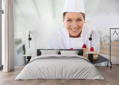 smiling pastry chef showing desserts on plate Wall mural