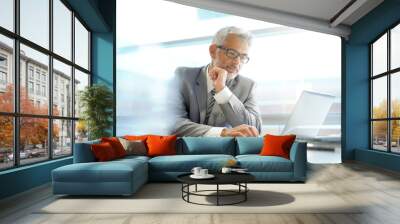 Stylish businessman working at desk in contemporary office Wall mural