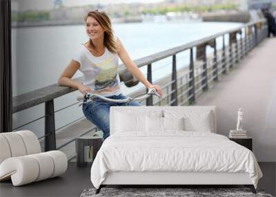 woman with bicycle relaxing by river Wall mural