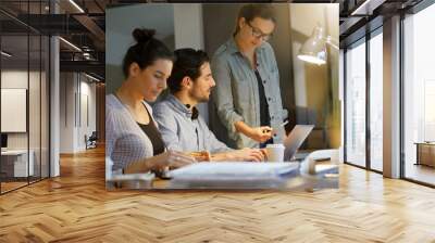 Work colleagues going over project in co working space Wall mural