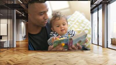 young african-american man reading book story to baby girl Wall mural