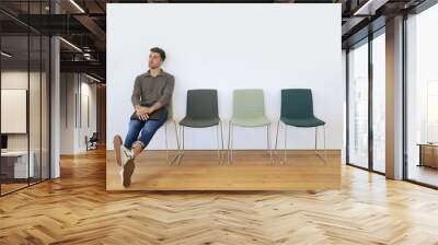 Young man in waiting room for job interview Wall mural