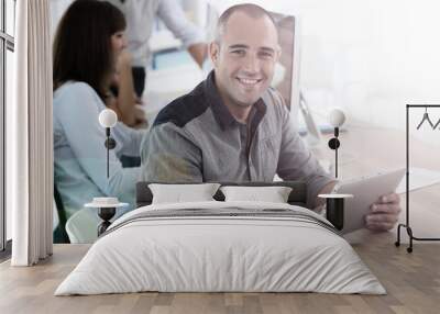 Young smiling man in training class using digital tablet Wall mural