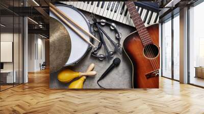 a group of musical instruments including a guitar, drum, keyboard, tambourine. Wall mural