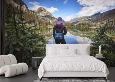 a young woman hiking next to a mountain lake Wall mural