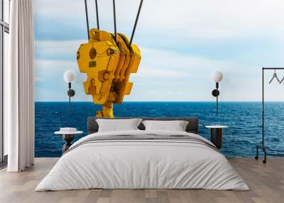 Crane hook in the sea with sky and clouds background on offshore platform Wall mural