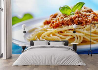 Spaghetti bolognese with basil and parmesan on white plate isolated, blue tablecloth Wall mural