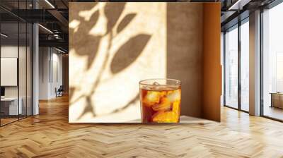 Spiced Apple Tea drink in modern off-white minimalist trendy stylish vegan plant-based cafe bar setting with stucco concrete wall, product photography, outdoors, sunny, beverage, bright, shadow play Wall mural